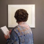 Woman looking at photograph and writing