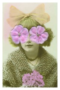 Woman in coat and hat with pink flowers for eyes.