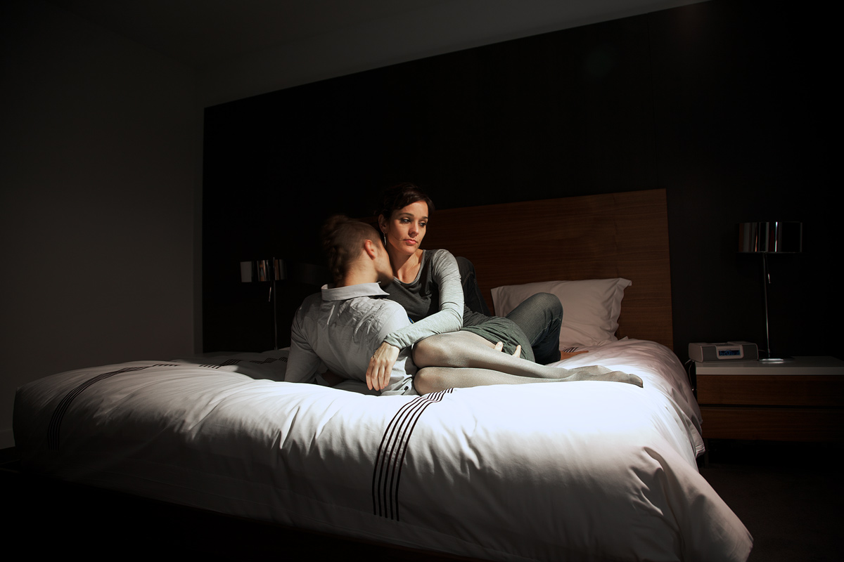 A man and woman on a bed.