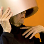 An elderly woman under the hair dryer at the beauty parlor.