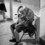 A man dressed as Santa asleep on a porch.