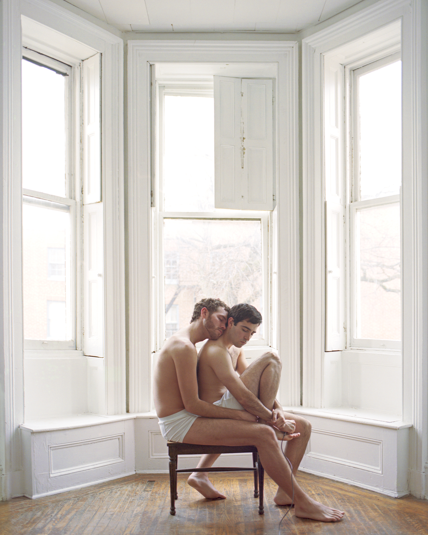 Two men sitting in a window.