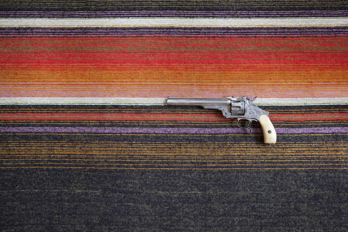A gun on an orange rug.