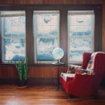 A living room in winter with large windows showing the winter scene.