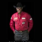 An African American cowboy in red shirt and black hat.