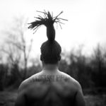 a man's back and with a pony tail on top of head pointing upward.