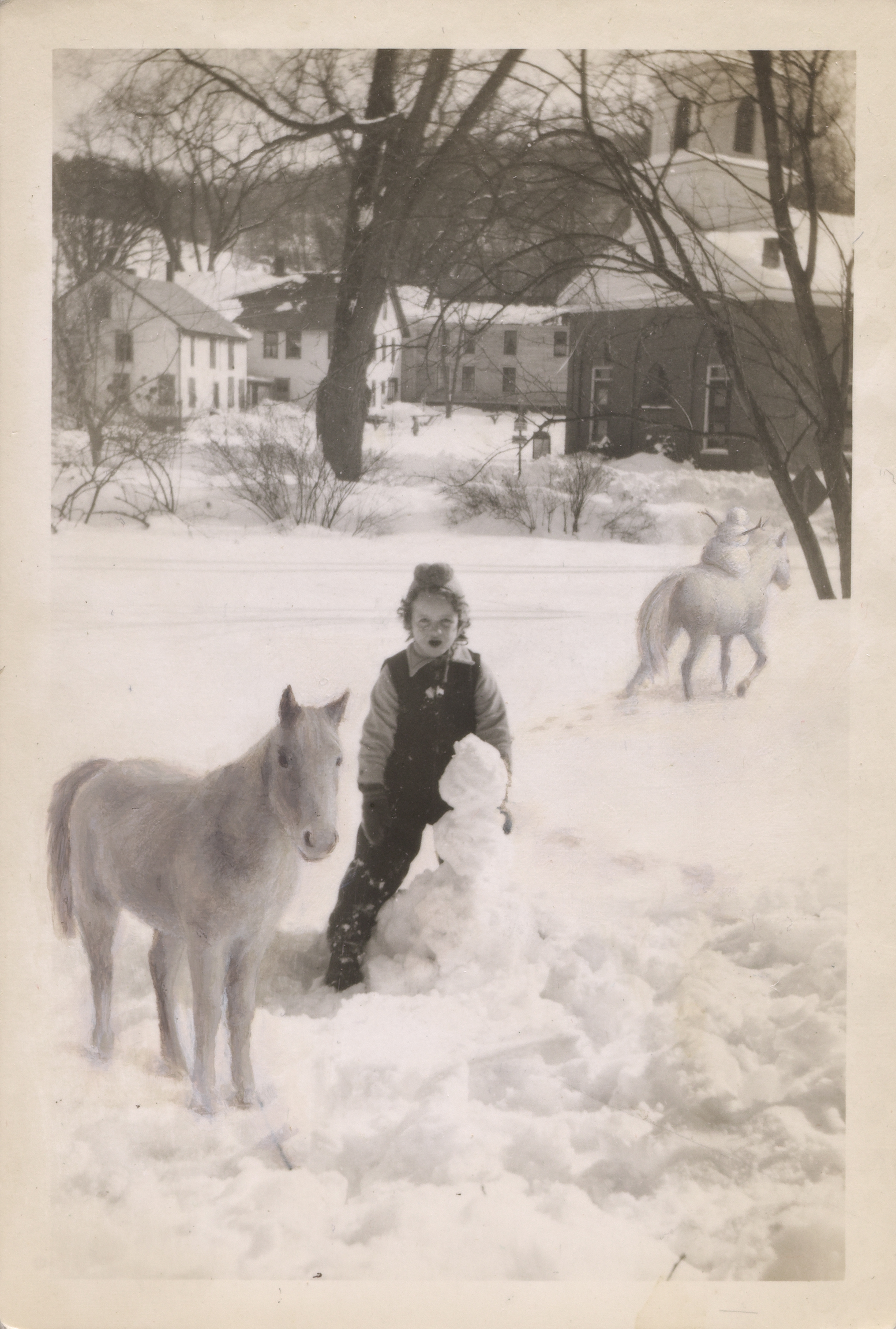 Child, horses and snowman in the winter