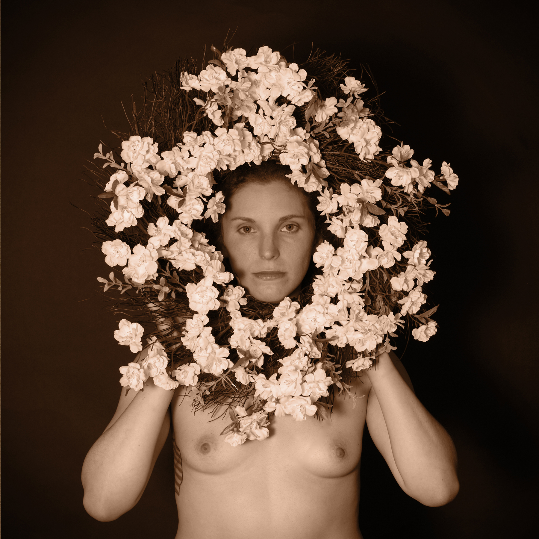 Nude woman with flower wreath around here face