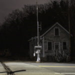Railroad crossing and house at night