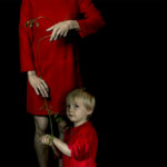 Woman in red dress next to child with red shirt