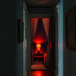 Red lamp and curtains down a hallway