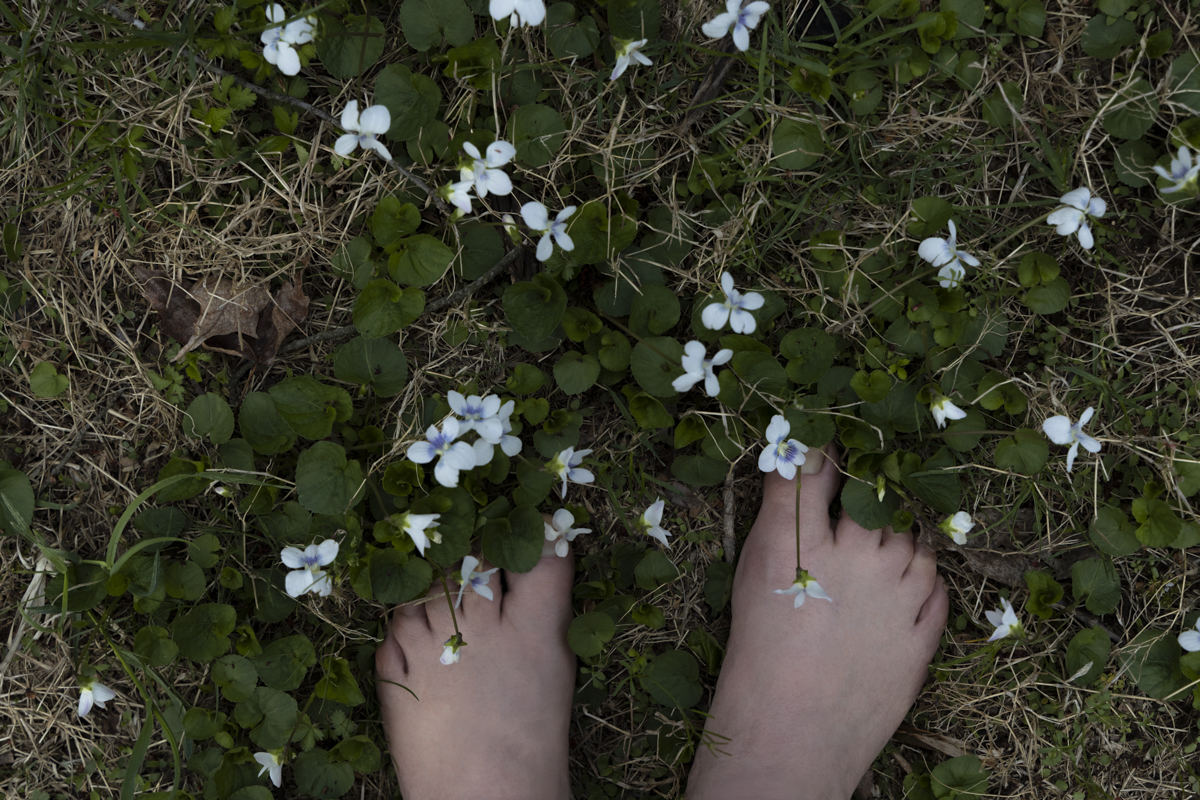 bare feet in grass with white flowers