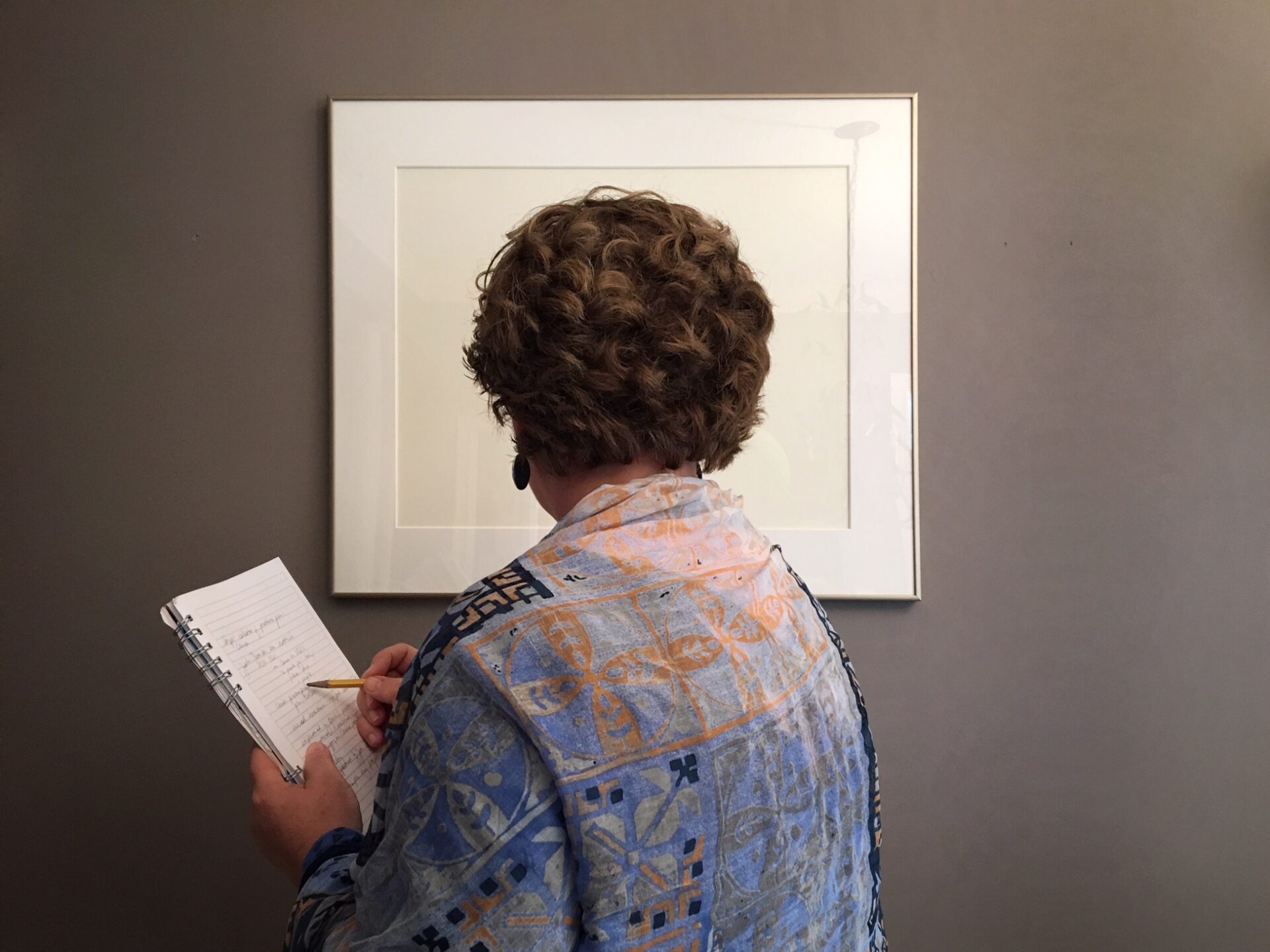 Woman looking at photograph and writing