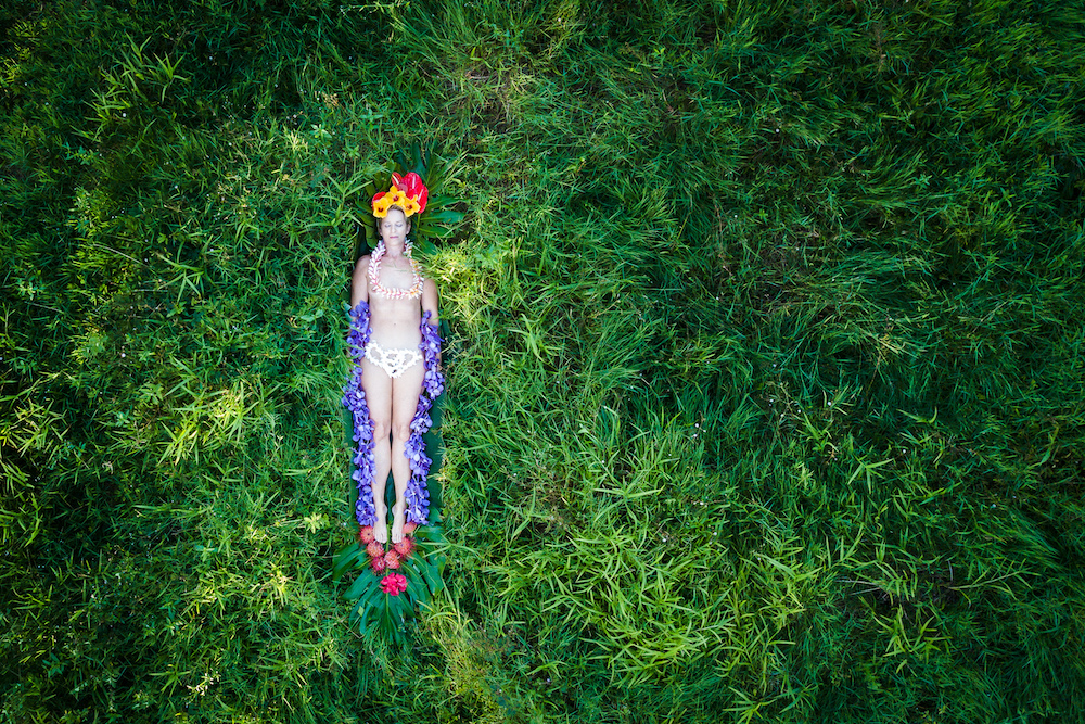 A nude woman lies in the greenery.