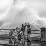 Group of people watching huge waves come in