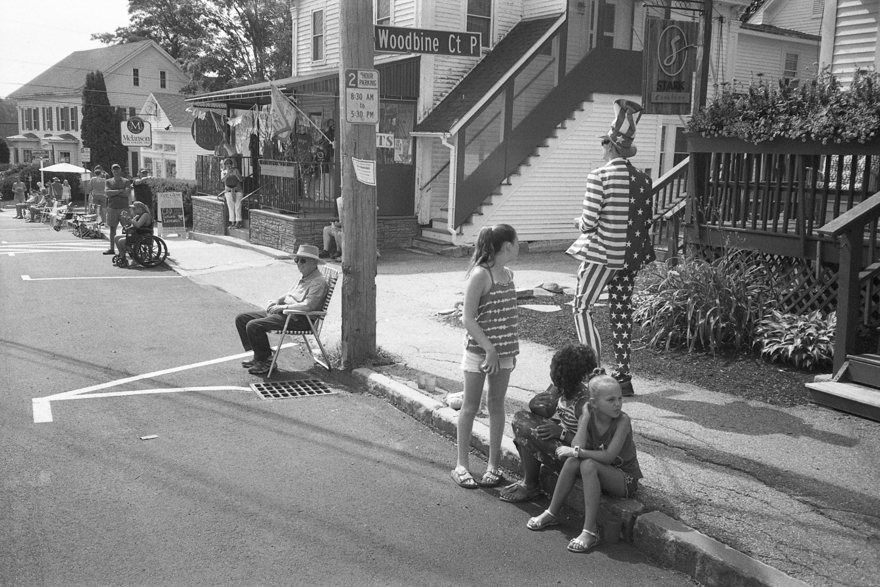 People sitting on a street with Uncle Sam walking by