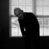An older man is in front of a window. He is bent over slightly. © Virgil DiBiase, 