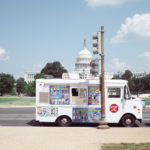 An ice-cream truck in front of the capitol building.
