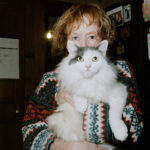 An older woman holds a cat