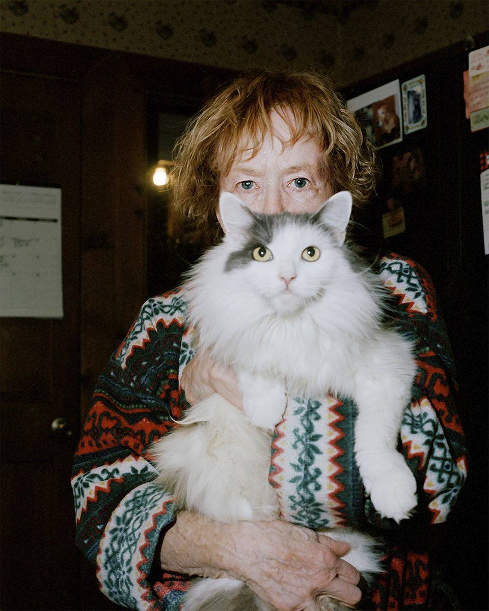 An older woman holds a cat