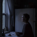 woman in dark at window