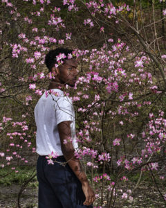 young man in front of blooming bush