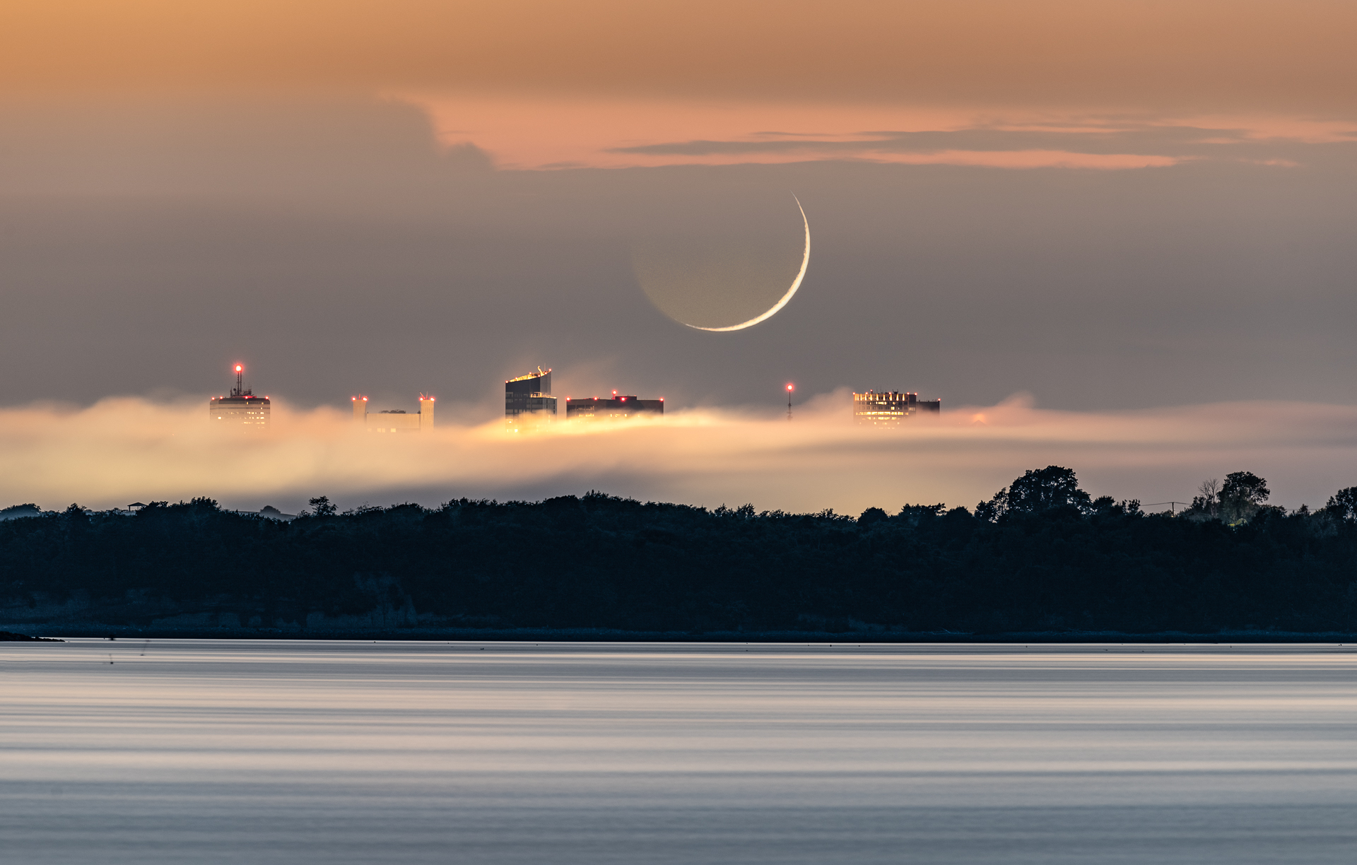 slit of moon over water in Boston