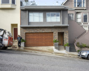 house with man washing the sidewalk