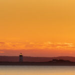 orange sunset with lighthouse